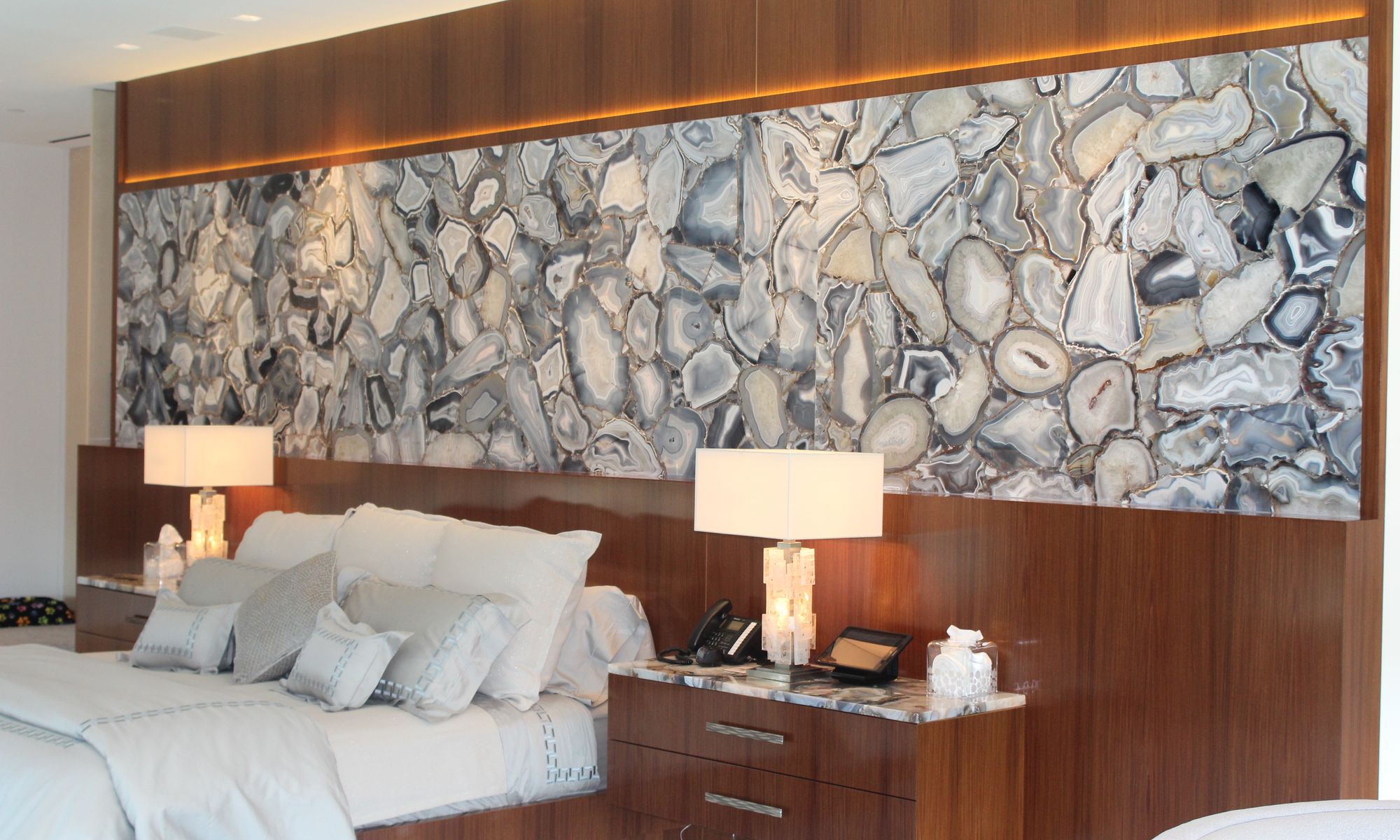 Backlit agate feature wall behind a bed, fabricated and installed by ERA